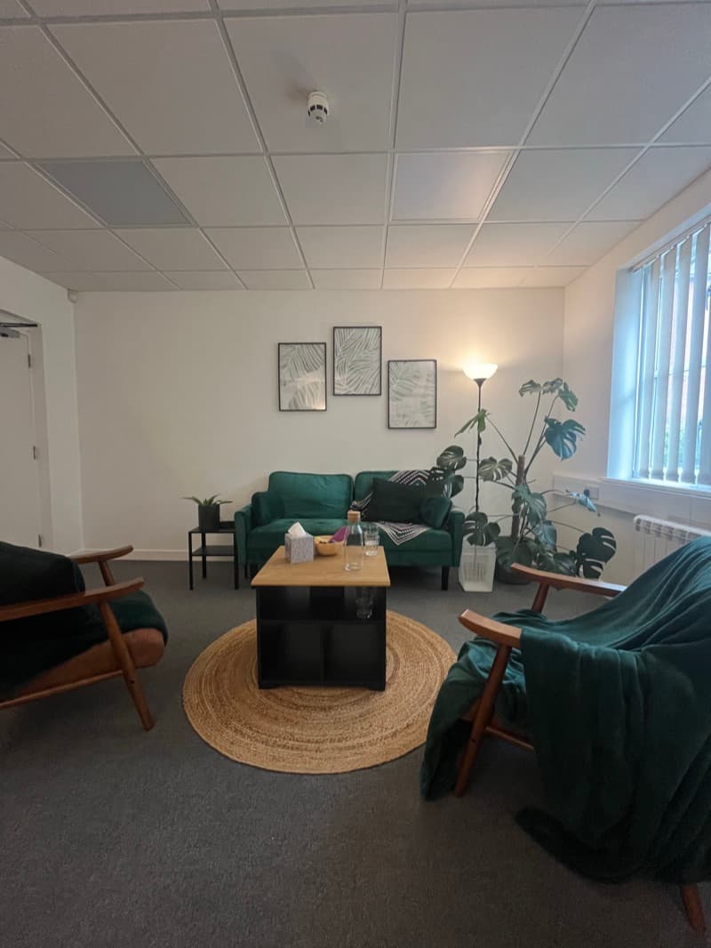 Therapy room at Colchester Business Centre — soft lighting, plants, comfortable seating, and fidgets available